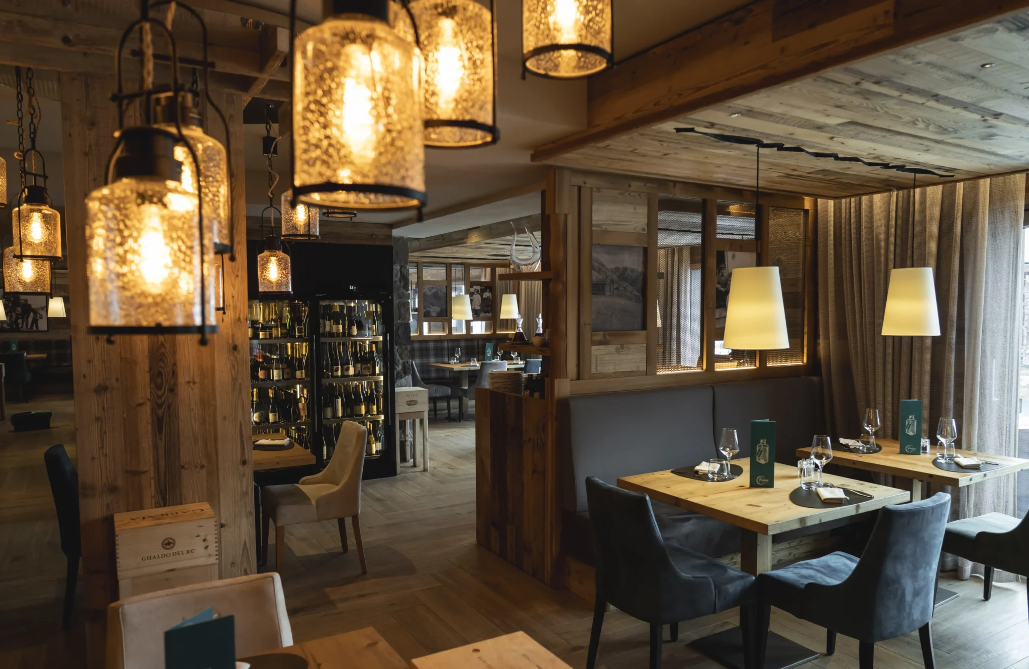 Ristorante accogliente con lampade a gabbia, tavoli apparecchiati e arredi in legno rustico