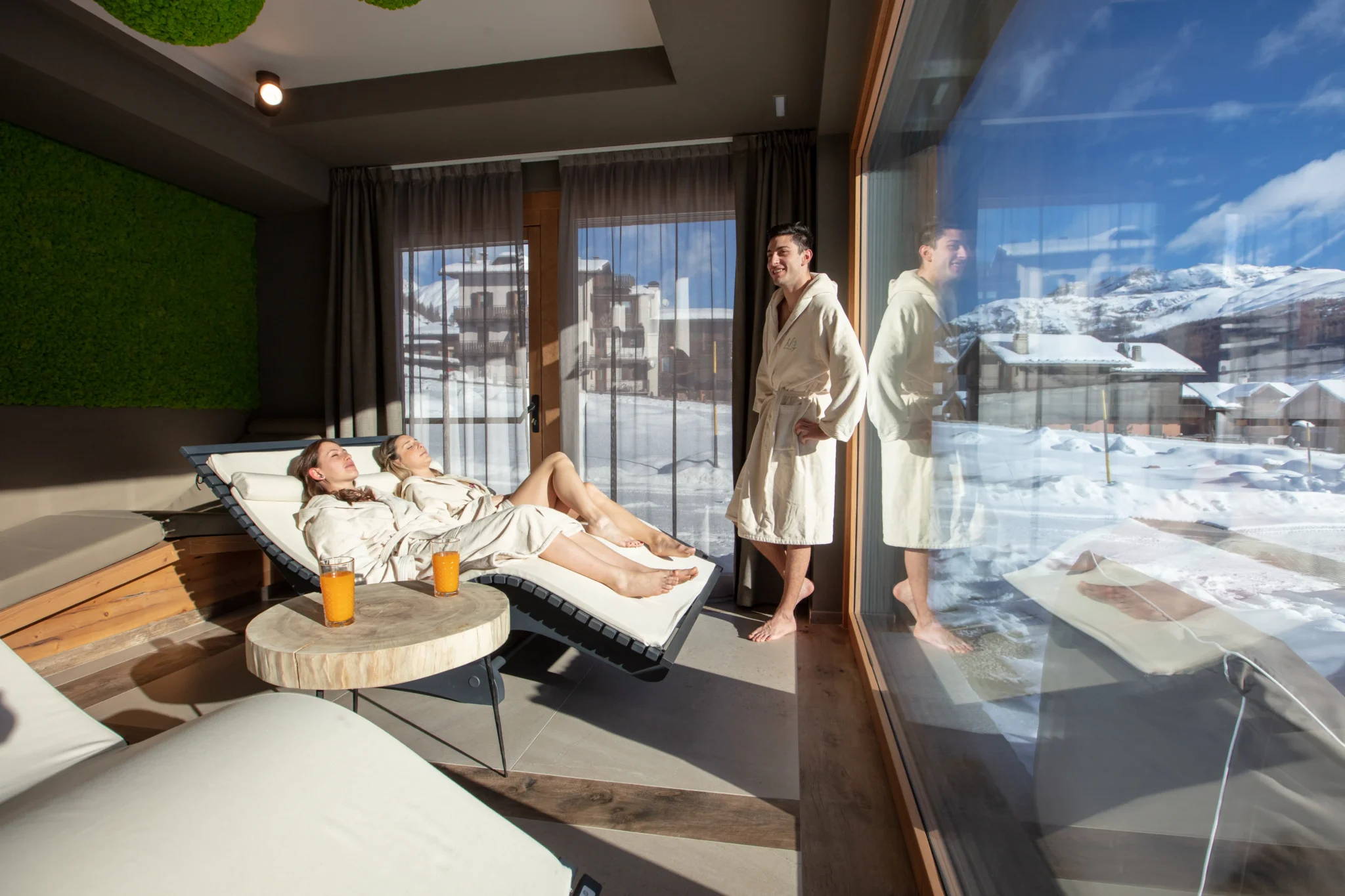 Coppia in accappatoio si rilassa nella zona relax della spa con vista sulle montagne di Livigno