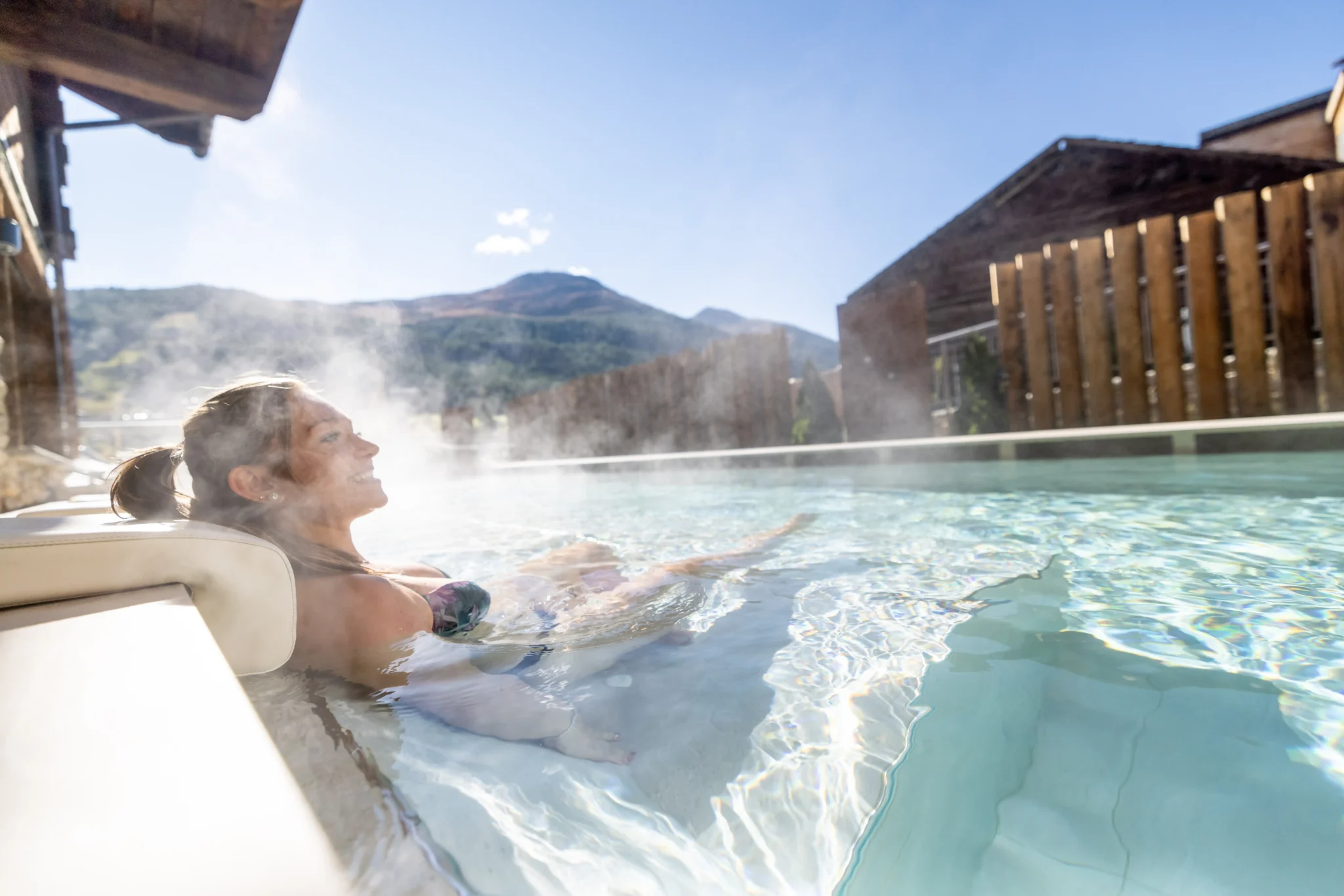 Coppia rilassata nella piscina esterna riscaldata con vista sulle montagne di Livigno